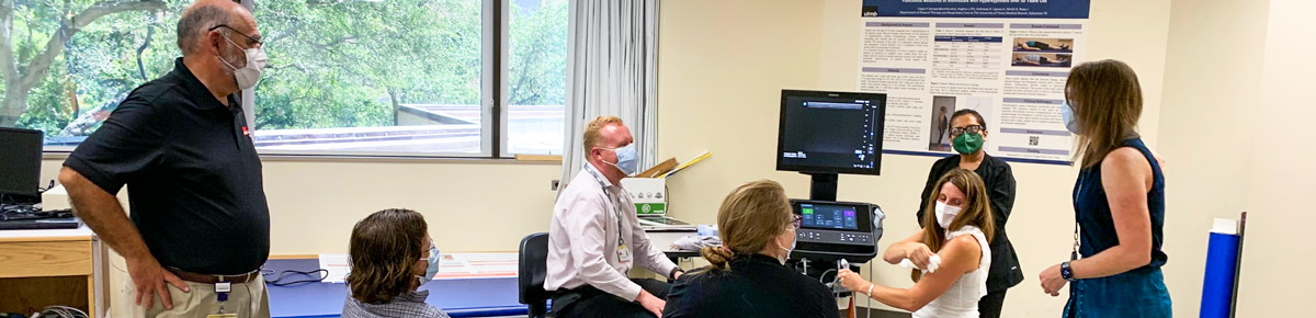 A group of people looking at a student speaking in a small classroom