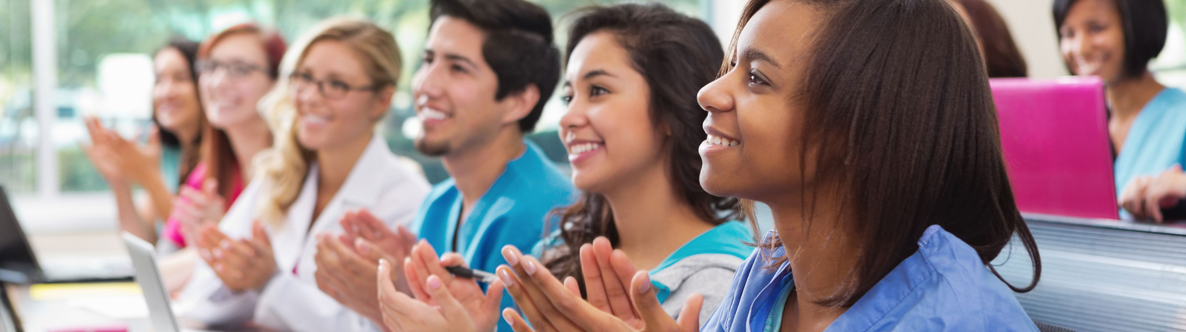 Group of students in class applauding.