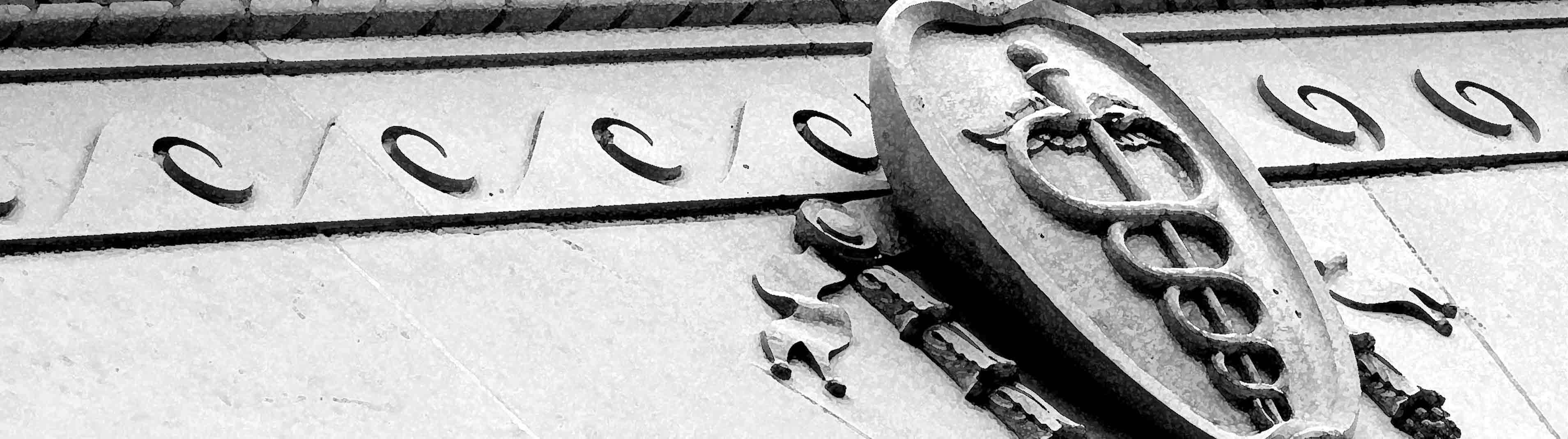 Image of a stone caduceus symbol on a building facade