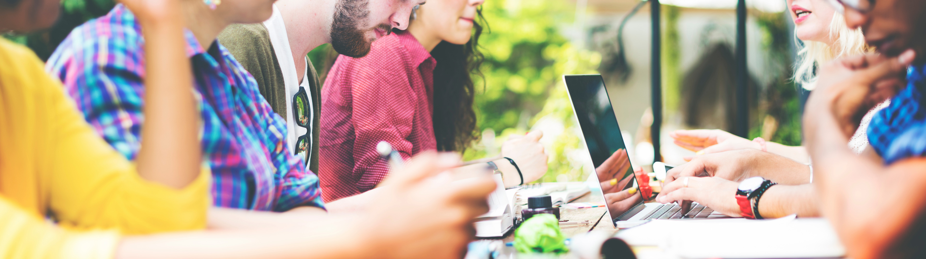 Close up image of students sitting at a table and chatting