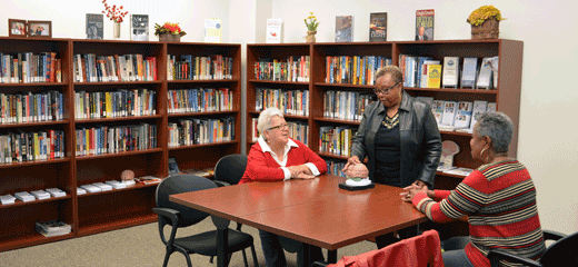 group of senior women at table in front of books