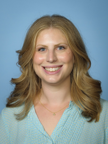 Professional headshot of an individual wearing a light blue dress shirt and a light gray tie against a solid blue background.
