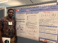 HPTM Student John Ekale smiling at the camera during his poster presentation at the 2025 GSBS Research expo