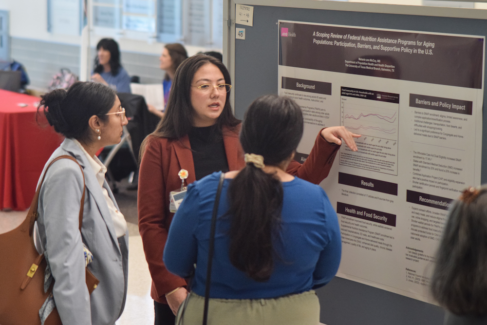 A student presents a poster on federal nutrition assistance programs for aging populations to two attendees.
